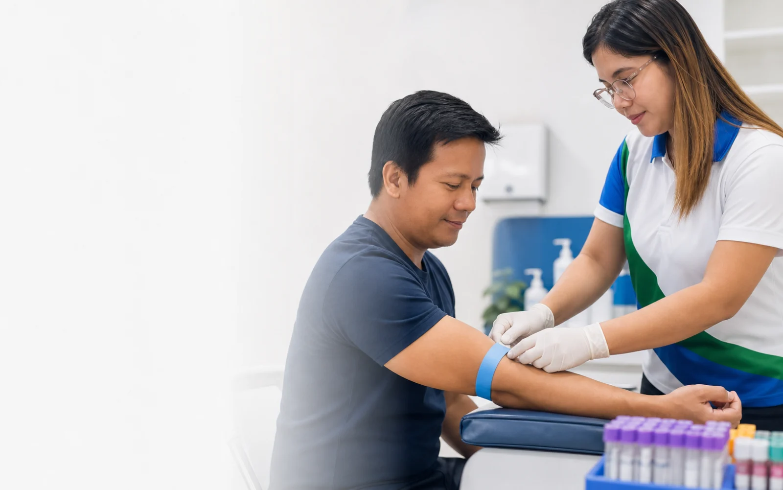 Illustrative scene of a Filipino medical technologist preparing a patient for blood extraction